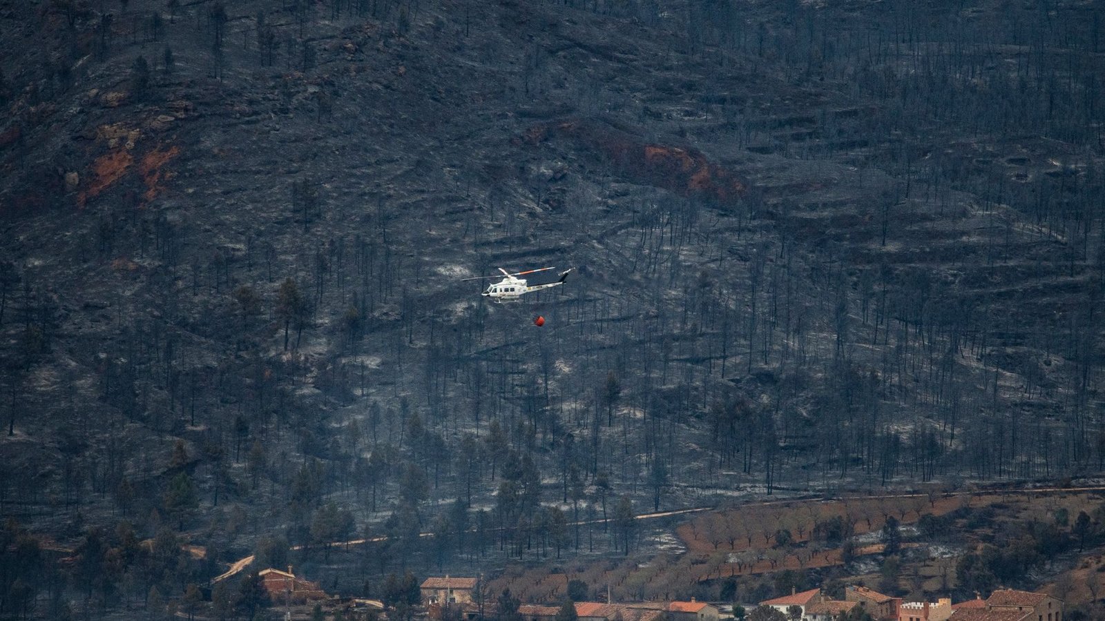 Ein Hubschrauber fliegt in San Agustin über ein verbranntes Gebiet. Vom Wald ist nicht mehr viel übrig.Foto: Lorena Sopêna/EUROPA PRESS/dpa