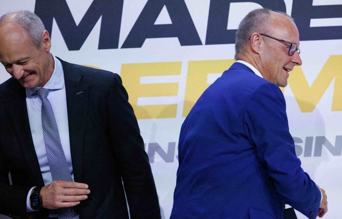 Bundeskanzler Friedrich Merz (CDU, r) geht auf dem Weg zum Rednerpult an Roland Busch, Vorstandsvorsitzender von Siemens, vorbei bei der Veranstaltung der Vorstellung der Jahresbilanz der Initiative Made for Germany. Merz hat Investoren aus der Wirtschaft grundlegende Reformen in Deutschland zugesagt.<span class='image-autor'>Carsten Koall/dpa</span>