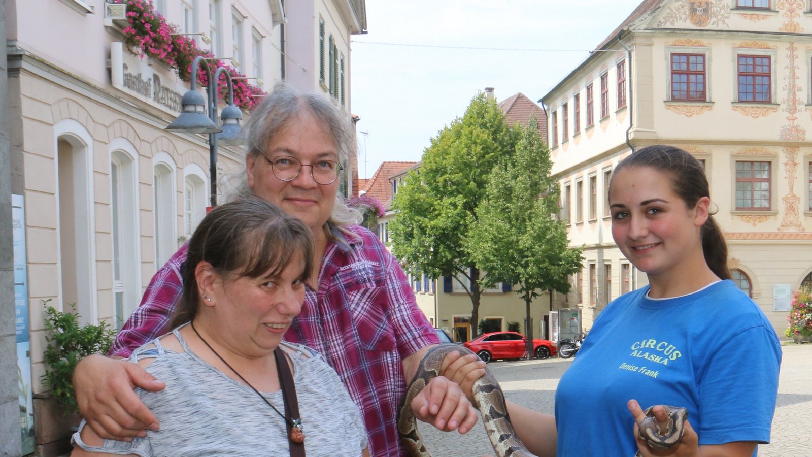 Ein kleiner Auflauf mit Schlange bildete sich, als Denise Frank und ihre Tigerpython Anna bei der VKZ vorbeischauten. Christine Raddatz, die zufällig vorbeikam, leidet eigentlich eher an einer Schlangenphobie, traute sich aber doch, das Reptil mal anzufassen. „Ledrig“ und „war ok“, lautete das Fazit der Vaihingerin. Schlange Anna gehört zur über 40-köpfigen Tiergruppe des Zirkus Alaska, der gerade in Ensingen beim Perfekten Standort gastiert. Am Donnerstag (28. Juli) ist ab 16.30 Uhr Familientag, ebenso am Freitag um 16.30 Uhr. Auch am Samstag um 15 Uhr und Sonntag um 11 Uhr (30. und 31. Juli) heißt es Manege frei. Infos unter im Internet unter zirkus-alaska.de.  Foto: Rücker