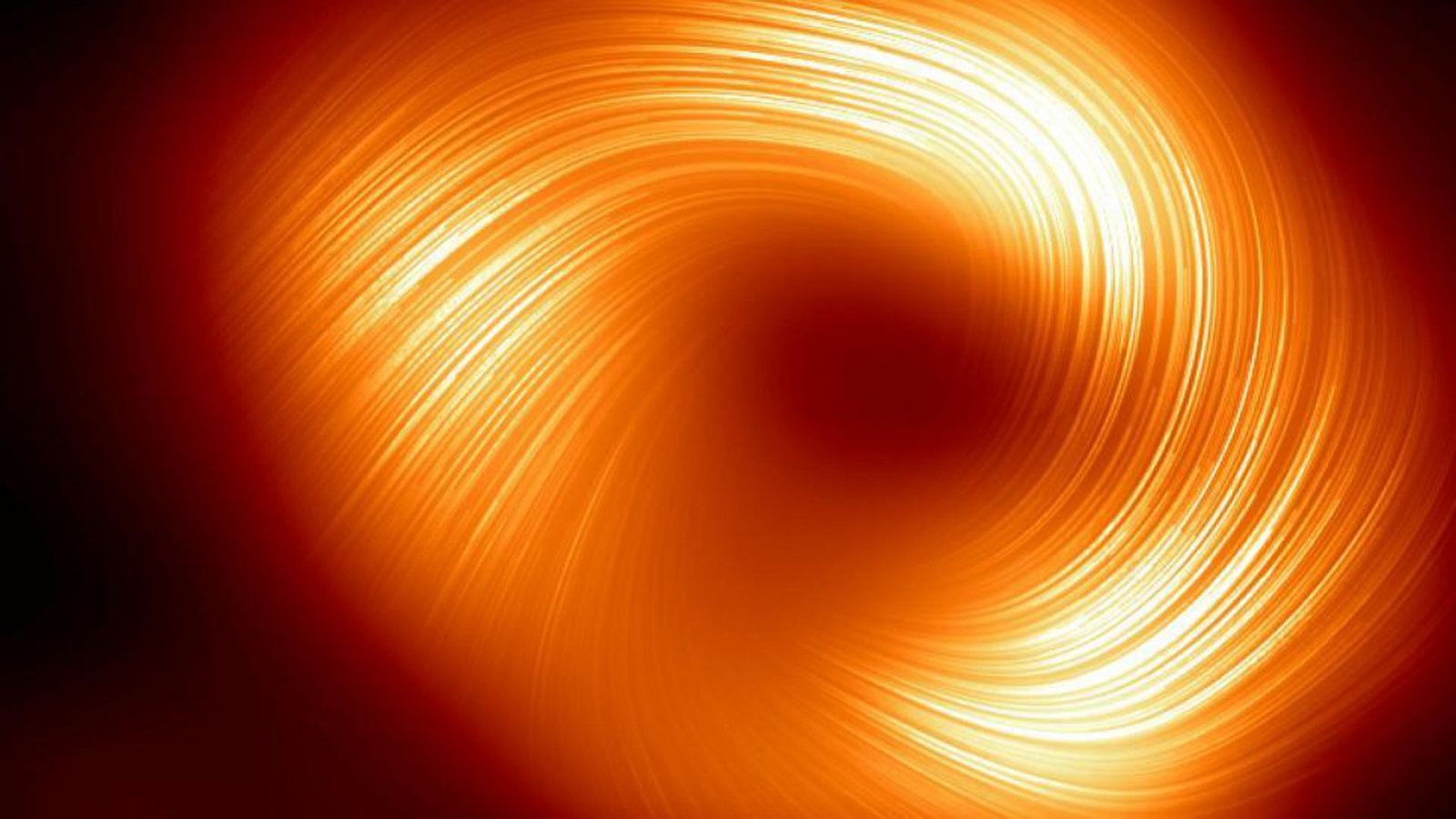 Blick auf das supermassereiche schwarze Loch Sagittarius A* im Herzen der Milchstraße im polarisierten Licht: Spiralförmig drehen sich die Magnetfelder um den zentralen Schatten des Schwarzen Lochs.Foto: EHT Collaboration/Eso