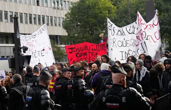 Demonstranten stehen in Frankreich Polizisten gegenüber, während eines Protests gegen die schlechten Bildungsbedingungen an Schulen.<span class='image-autor'>Teresa Suarez/AP/dpa</span>