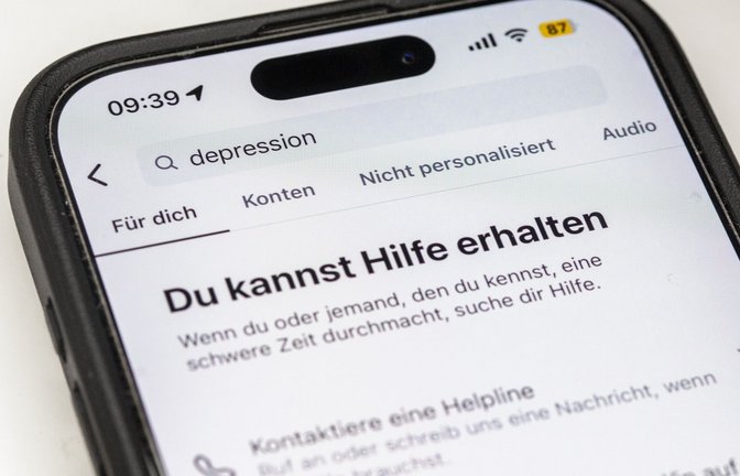 Auf einem Smartphone ist eine Suchansicht innerhalb einer Social-Media-App zu sehen, die bei dem Begriff „Depression“ Hinweise auf Hilfsangebote und Unterstützung einblendet. Plattformen wie Instagram zeigen bei sensiblen Suchbegriffen zunehmend Sicherheitshinweise und Verlinkungen zu professionellen Beratungsstellen. Sie reagieren damit auf die wachsende Rolle sozialer Medien bei der Informationssuche zu psychischen Belastungen.<span class='image-autor'>Foto: Fernando Gutierrez-Juarez/dpa</span>