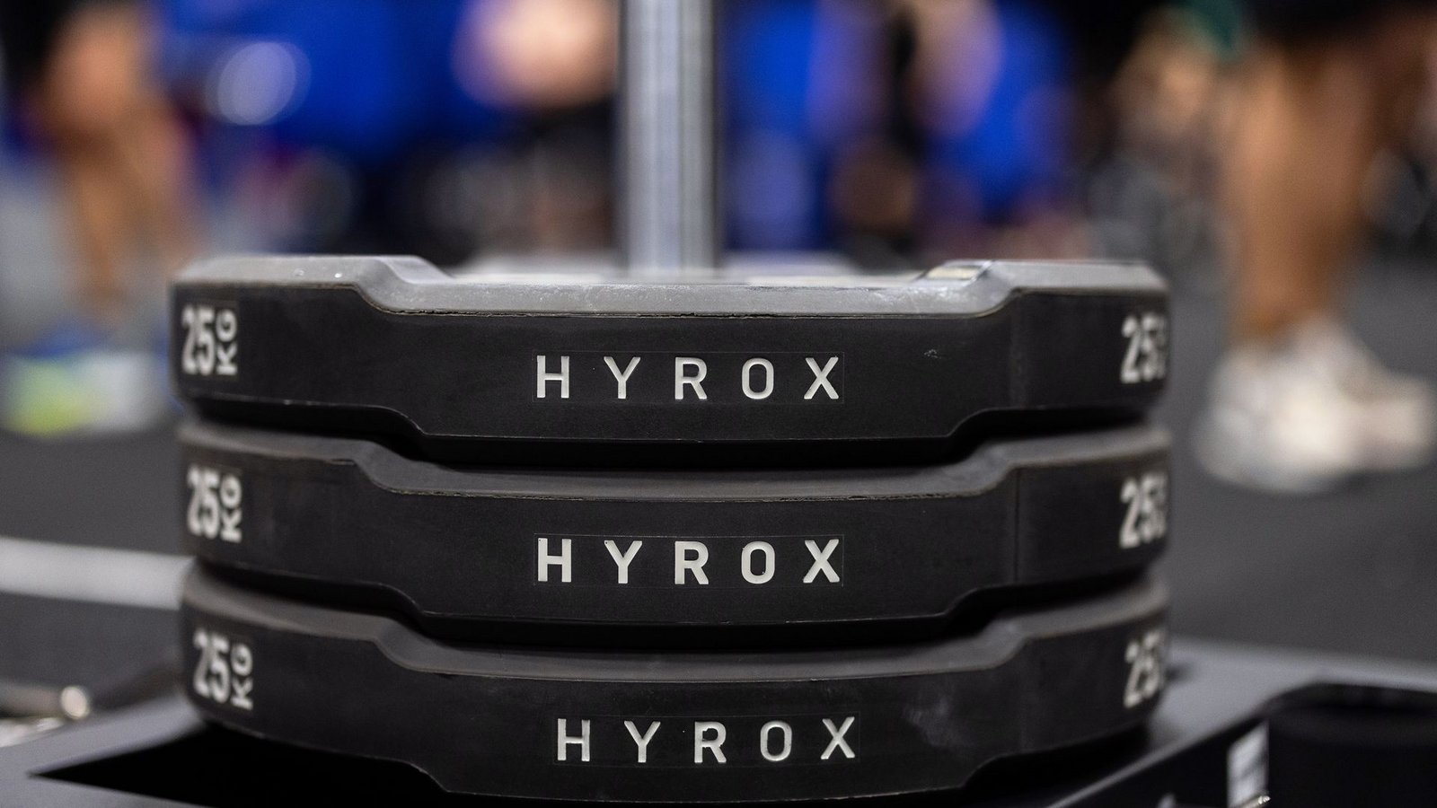 Hantelscheiben mit dem Schriftzug Hyrox an einem Messestand, wo wenig später ein Lauf- und Workout-Wettbewerb stattfinden sollte.Foto: Rolf Vennenbernd/dpa