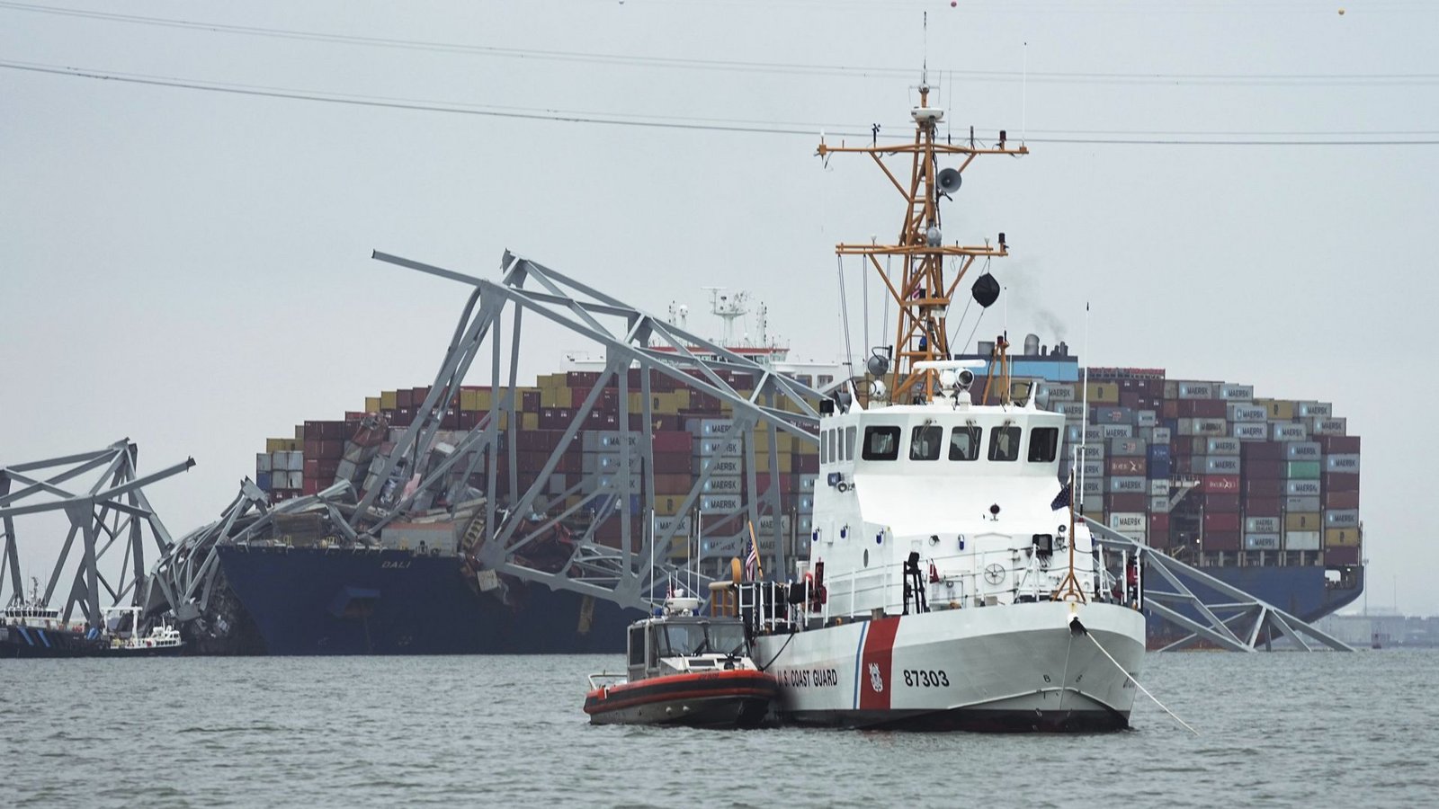 Ein Kutter der Küstenwache patrouilliert vor einem Containerschiff, das unter einem Teil der Francis Scott Key Bridge festsitzt.Foto: dpa/Steve Helber