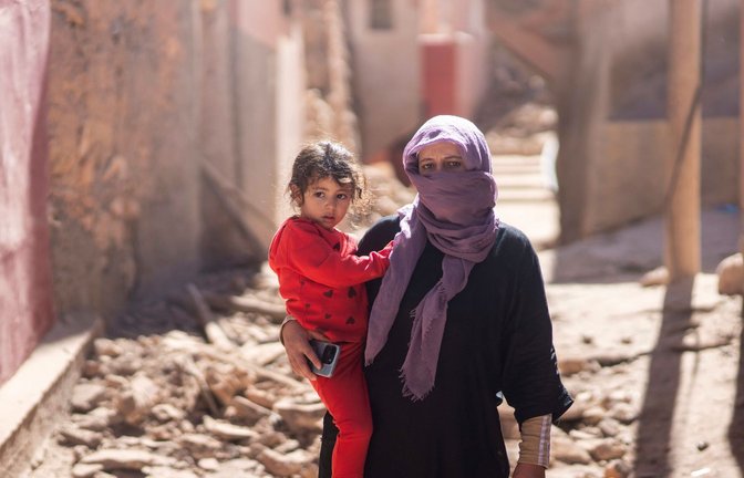 Nach dem schweren Erbeben in Marokko steht eine Frau mit ihrer Tochter vor ihrem Haus südlich von Marrakesch.<span class='image-autor'>Foto: Mosa'ab Elshamy/AP/dpa</span>