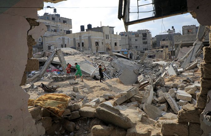 Während Kinder zwischen den Trümmern zerstörter Häuser spielen, halten die indirekten Verhandlungen über einen Geisel-Deal im Gaza-Krieg weiter an.<span class='image-autor'>Foto: Rizek Abdeljawad/XinHua/dpa</span>