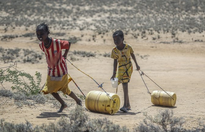 Zwei junge Mädchen ziehen Wasserbehälter auf dem Rückweg zu ihren Hütten im kenianischen  osion
Umweltzerstörung.<span class='image-autor'>Foto: Brian Inganga/AP/dpa/Brian Inganga</span>