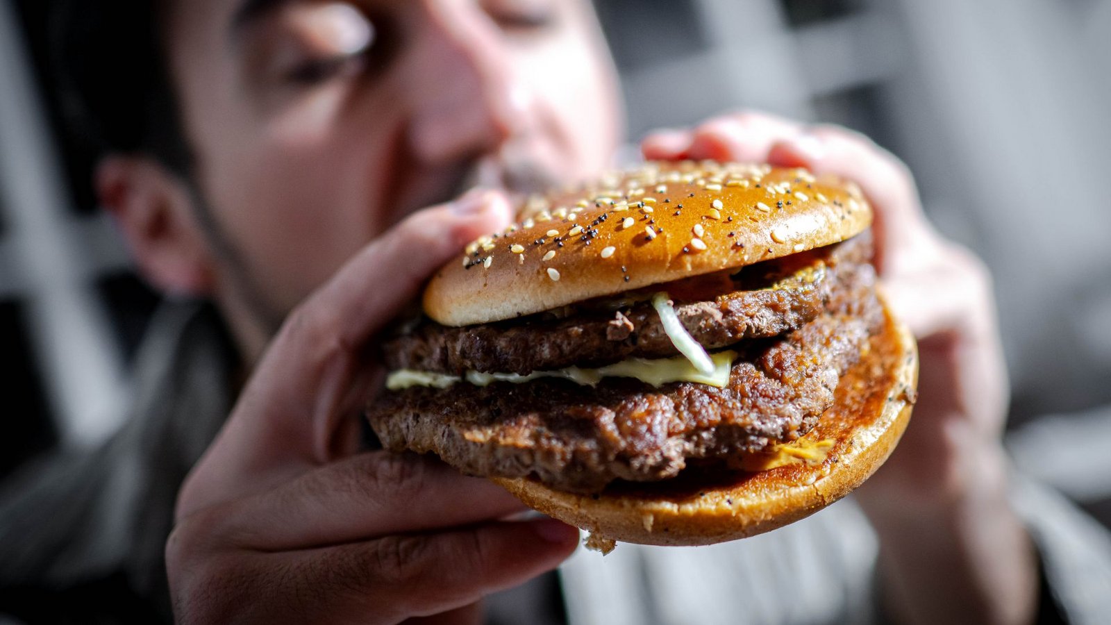 Illustration - Ein Mann beißt in einen BurgerFoto: Sina Schuldt/dpa/dpa-tmn