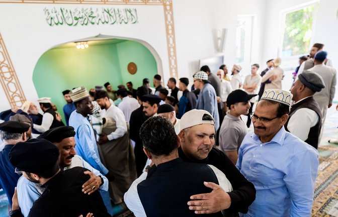 Gläubige umarmen sich bei den Feierlichkeiten zum Opferfest Eid al-Adha in der Khadija Moschee der Ahmadiyya-Muslim-Jamaat Berlin.<span class='image-autor'>Foto: Christoph Soeder/dpa/Christoph Soeder</span>