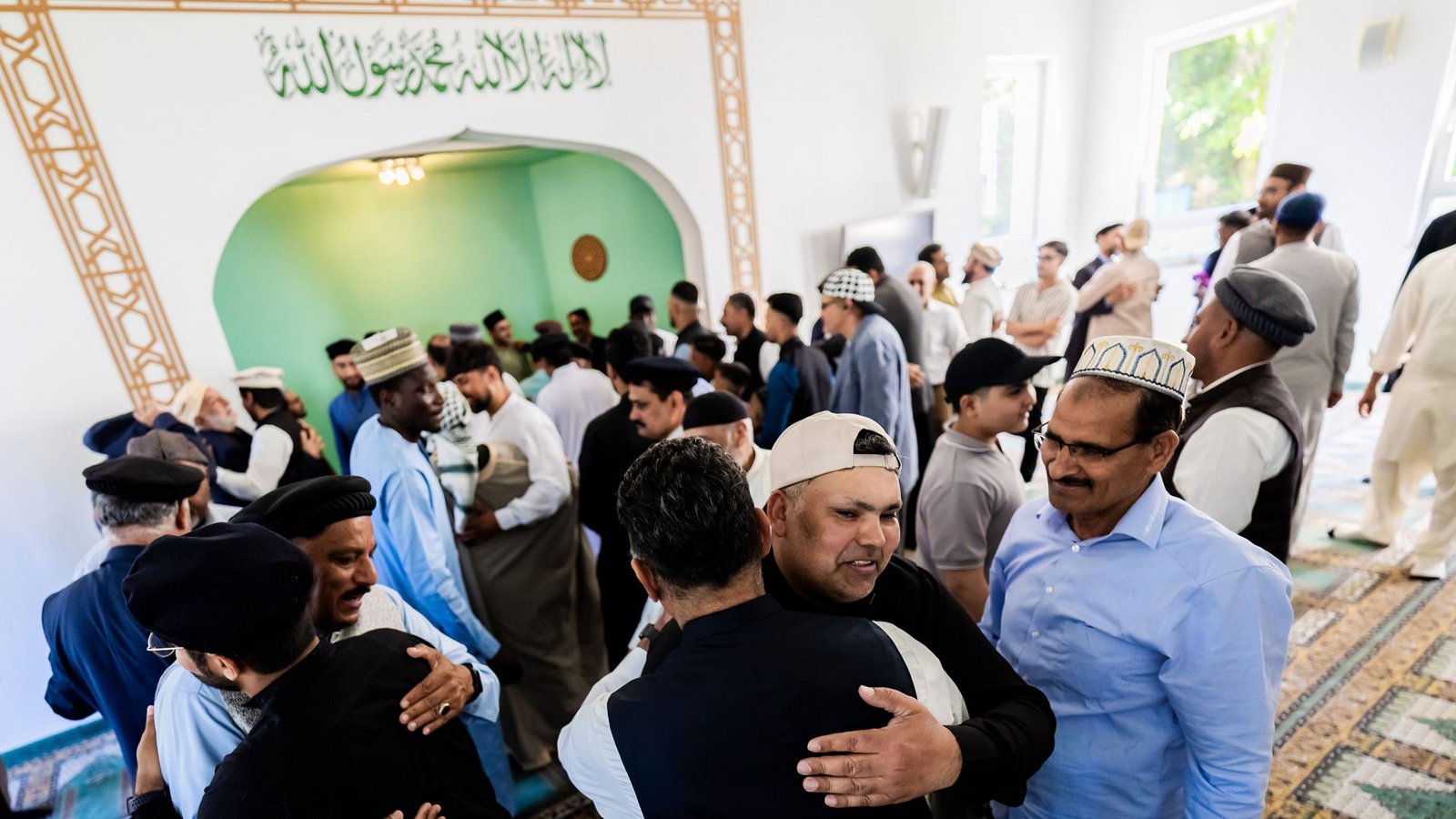 Gläubige umarmen sich bei den Feierlichkeiten zum Opferfest Eid al-Adha in der Khadija Moschee der Ahmadiyya-Muslim-Jamaat Berlin.Foto: Christoph Soeder/dpa/Christoph Soeder