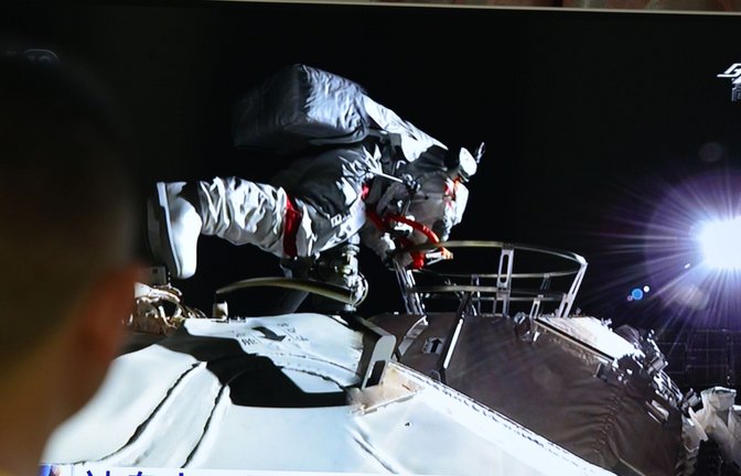 Ein Mann verfolgt vor dem Fernseher die Live-Übertragung eines Außeneinsatzes an der Raumstation "Tiangong" (Archivbild).<span class='image-autor'>Foto: Sheldon cooper/SOPA Images via ZUMA Wire/dpa</span>