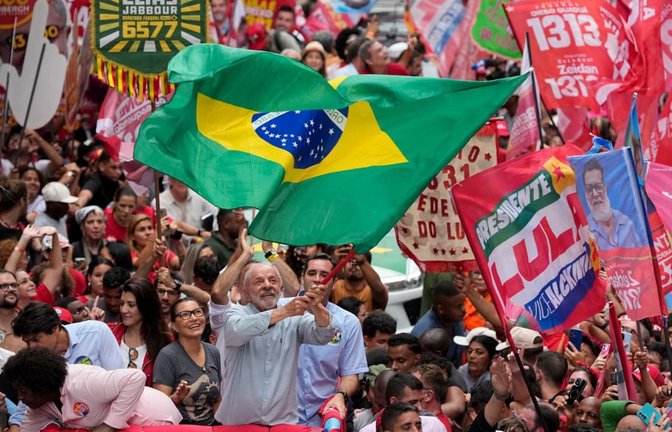 Wahlkampf in Brasilien: Der brasilianische Präsident Luiz Inacio Lula da Silva (M.), der sich um die Wiederwahl bewirbt, schwenkt während einer Wahlkampfveranstaltung eine brasilianische Fahne. Die Wahl findet am 4. Oktober statt.<span class='image-autor'>Silvia Izquierdo/AP/dpa</span>