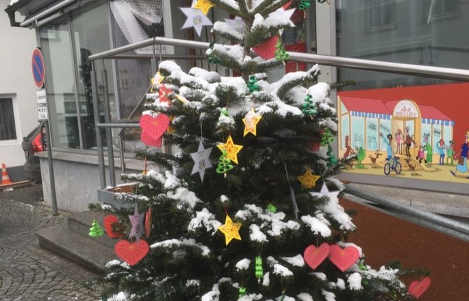 Der von den Kindern des katholischen Kindergartens liebevoll geschmückte Weihnachtsbaum vor dem Dorfladen in Enzweihingen ist zum ersten Mal im Winterkleid. <span class='image-autor'>Foto: ps</span>