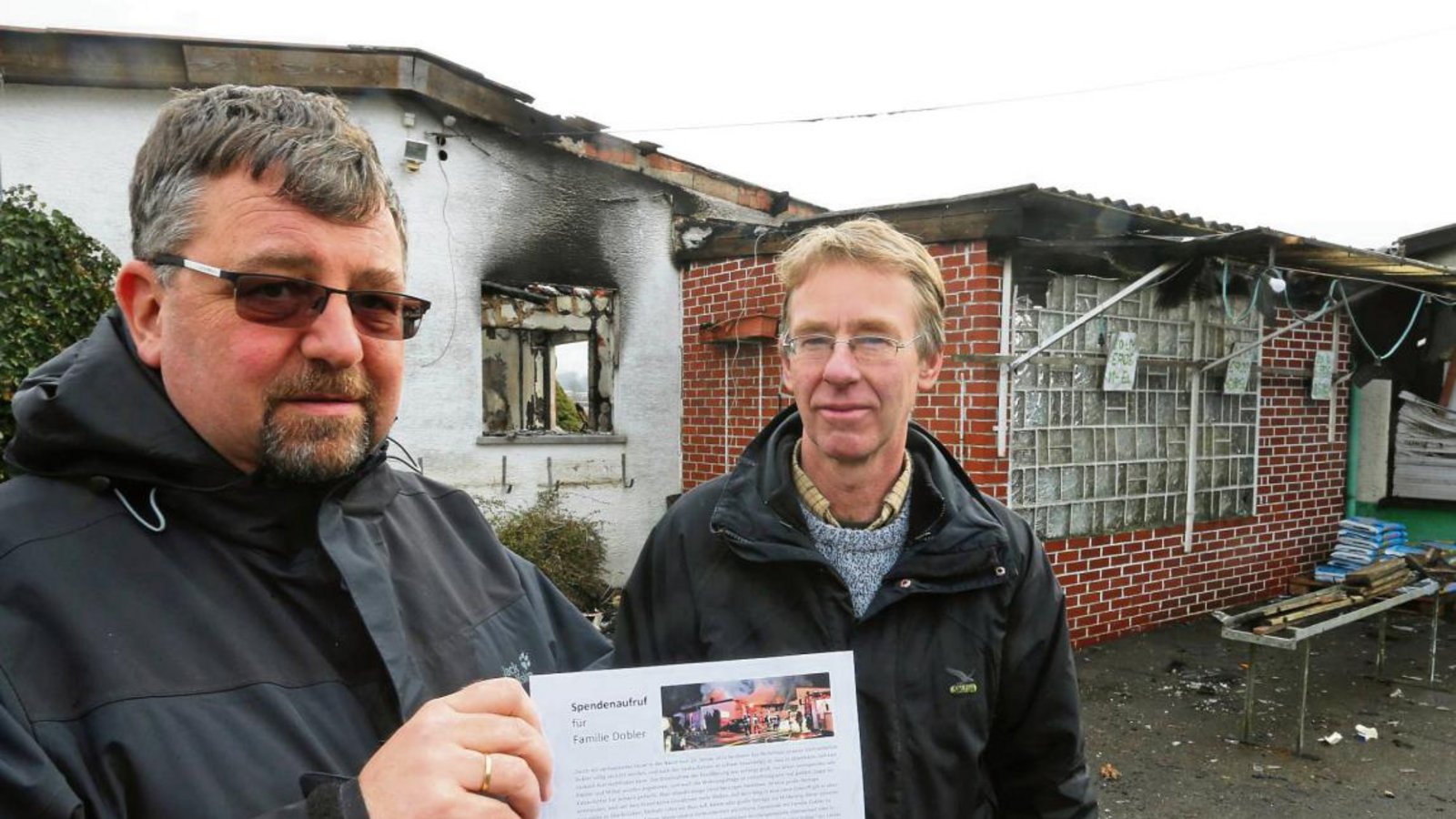 Sersheims Pfarrer Johannes Rau und Thomas Dobler mit dem Spendenaufruf der Kirchengemeinde vor der Brandruine an der Gärtnerei. Fotos: Küppers Sersheims Pfarrer Johannes Rau und Thomas Dobler mit dem Spendenaufruf der Kirchengemeinde vor der Brandruine an der Gärtnerei. Fotos: Küppers