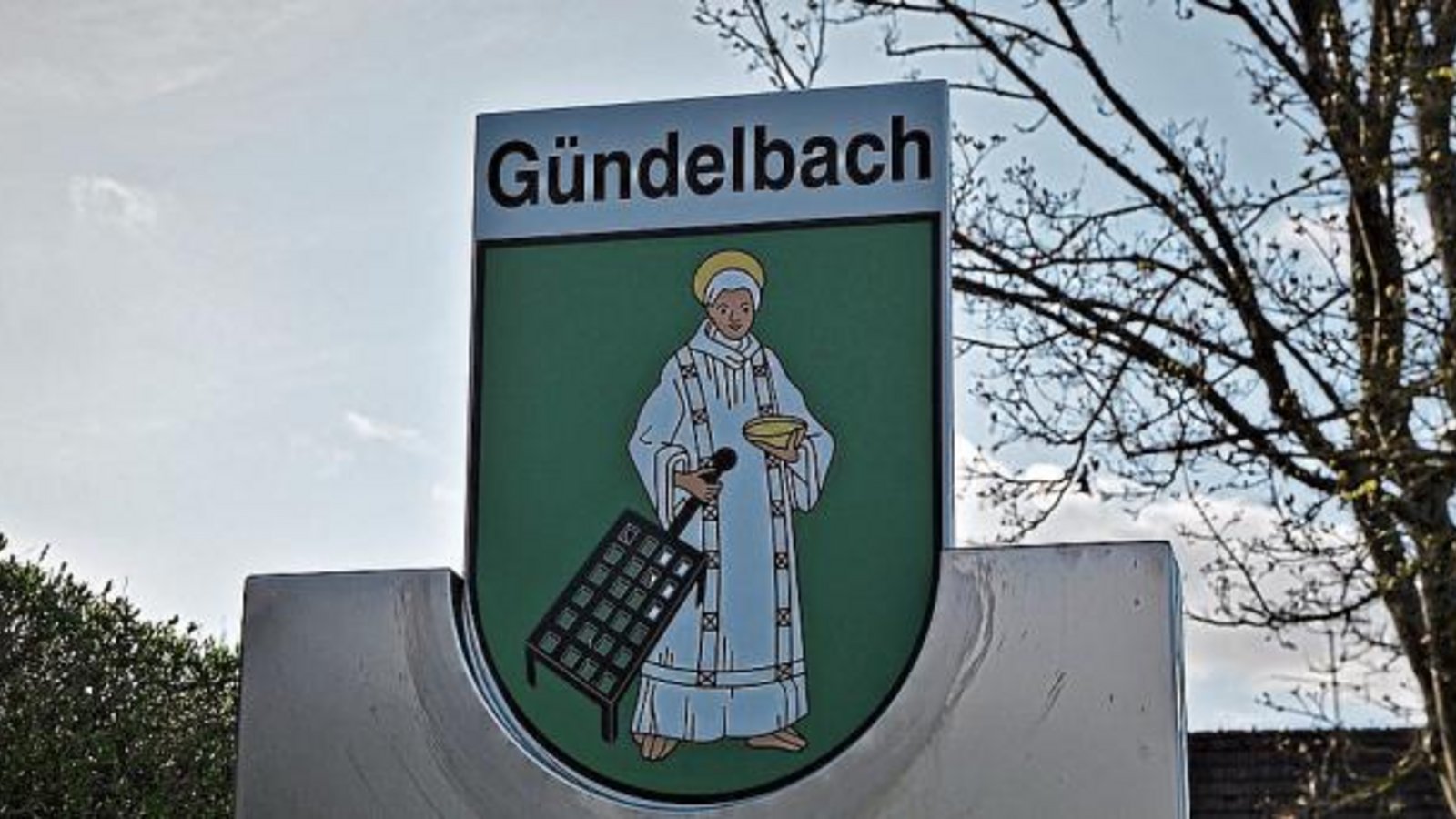 Die Ortsschilder in Gündelbach erstrahlen in neuem Glanz. Der Ortschaftsrat hat aus Verfügungsmitteln das Gündelbacher Ortswappen mit dem heiligen Laurentius erneuern lassen. Das Wappen zeigt den silbern gekleideten Laurentius mit goldenem Nimbus, in der rechten Hand einen schwarzen Rost, in der linken eine goldene Schale haltend. St. Laurentius, der Patron der Pfarrkirche und Weingärtner, wurde in Gündelbach bereits in dem 1563 nachgewiesenen Fleckensiegel geführt. pv/Foto: Thalhäuser Die Ortsschilder in Gündelbach erstrahlen in neuem Glanz. Der Ortschaftsrat hat aus Verfügungsmitteln das Gündelbacher Ortswappen mit dem heiligen Laurentius erneuern lassen. Das Wappen zeigt den silbern gekleideten Laurentius mit goldenem Nimbus, in der rechten Hand einen schwarzen Rost, in der linken eine goldene Schale haltend. St. Laurentius, der Patron der Pfarrkirche und Weingärtner, wurde in Gündelbach bereits in dem 1563 nachgewiesenen Fleckensiegel geführt. pv/Foto: Thalhäuser