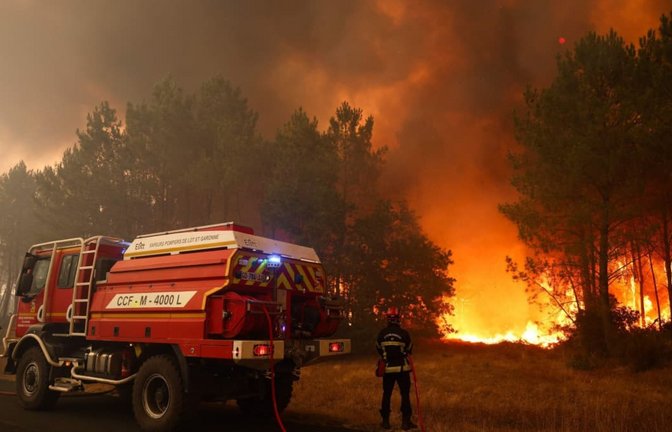 In der Nähe von Le Porge bekämpfen Feuerwehrleute lodernde Flammen. Im Südwesten des Landes wüten die größten Brände in der Geschichte Frankreichs.<span class='image-autor'>Romain Perrocheau/AFP/dpa</span>