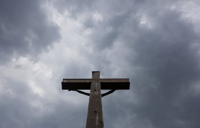 Regenwolken ziehen über einem Kreuz auf der Schwäbischen Alb auf.<span class='image-autor'>Thomas Warnack/dpa</span>