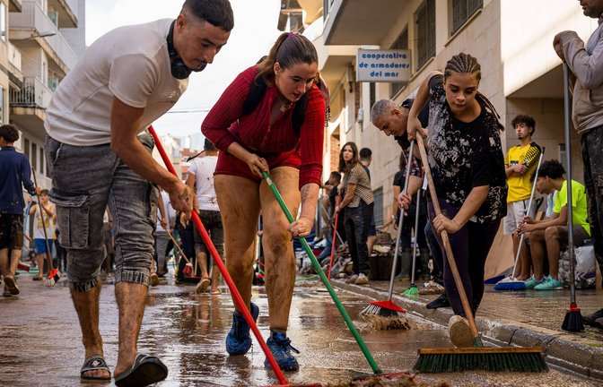 In Valencia packen Freiwillige gemeinsam an und säubern die Straßen per Besen vom Schlamm.<span class='image-autor'>Foto: Imago/ZUMA Press Wire</span>