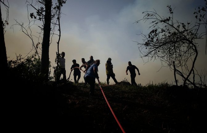 Einheimische und Feuerwehrleute versuchen, einen Waldbrand in Beykoz, einem Vorort von Istanbul, zu löschen. Nun bekämpfen Einsatzkräfte im Osten der türkischen Hauptstadt Ankara einen Waldbrand. (zu dpa: «Türkische Feuerwehr bekämpft Waldbrände in Antalya»)<span class='image-autor'>Emrah Gurel/AP/dpa</span>