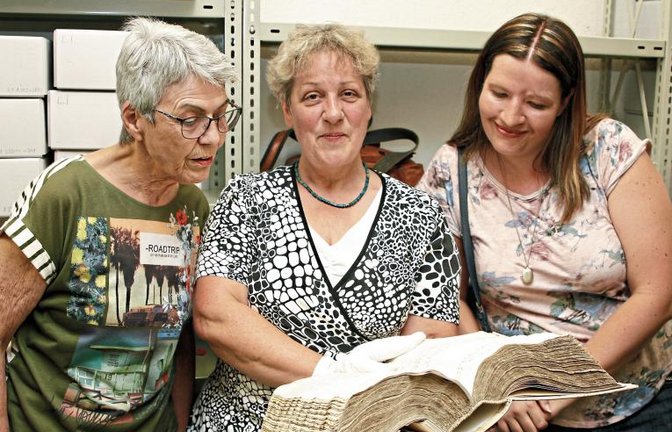 Claudia Lange (von links), Stadtarchivarin Marlis Lippik und Tanja Dobrosavljevic werfen einen Blick in ein Amtsbuch aus dem 16. Jahrhundert.  Foto: Kollros