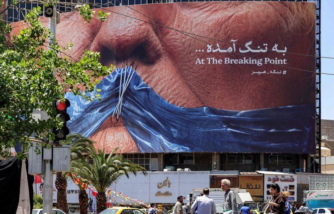 Ein Plakat in Teheran – US-Präsident Trump mit einem Stoffstück in der Form der Straße von Hormus vor dem zugenähten Mund<span class='image-autor'>Foto: AFP</span>