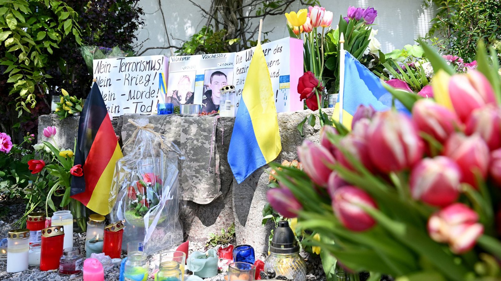 Neben dem Einkaufszentrums an dem die zwei Männer aus der Ukraine getötet worden sind, haben Menschen Blumen und Plakate niedergelegt.Foto: dpa/Angelika Warmuth