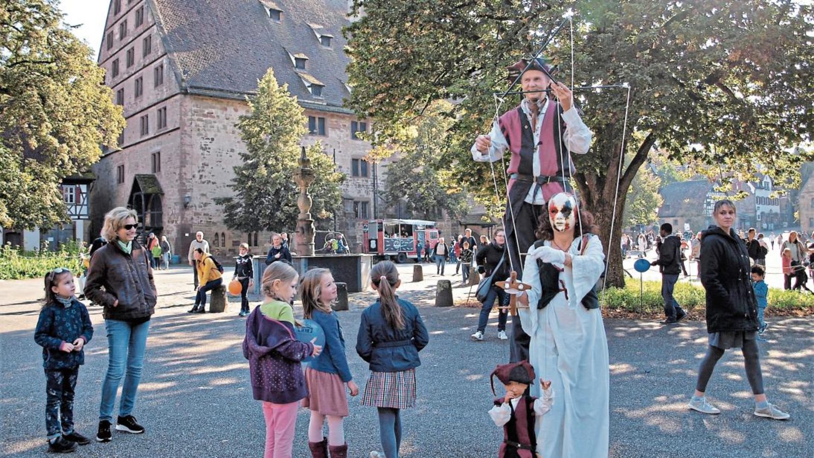 Ein Stelzenmann und eine Puppenspielerin bummeln zur Freude der Besucher über den Klosterplatz. Foto: Filitz Ein Stelzenmann und eine Puppenspielerin bummeln zur Freude der Besucher über den Klosterplatz. Foto: Filitz