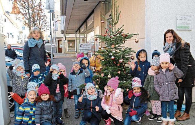 Mit dem Bus sind die Kinder des Kindergartens Steine aus Enzweihingen angereist, um den Weihnachtsbaum bei Mesinger Optik und Optometrie in Vaihingen zu schmücken. Selbst gebastelte Ton-Ausstecherle, Girlanden und selbst bemalte Kugeln zieren jetzt das Nadelbäumchen.  Foto: Rücker