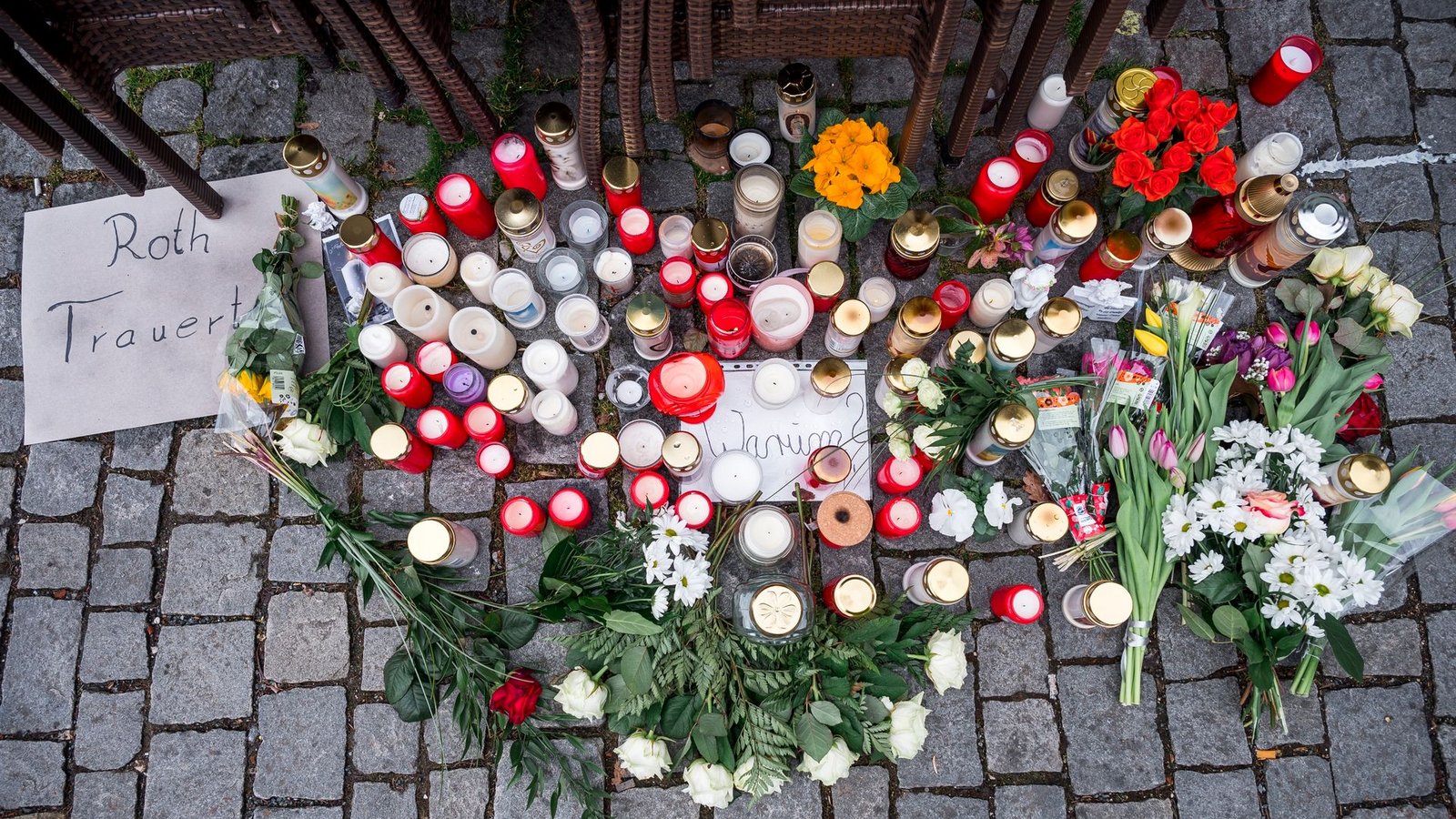 Auf dem Platz vor dem Blumengeschäft sind Blumen und Kerzen als Zeichen der Trauer niedergelegt.Foto: Daniel Vogl/dpa