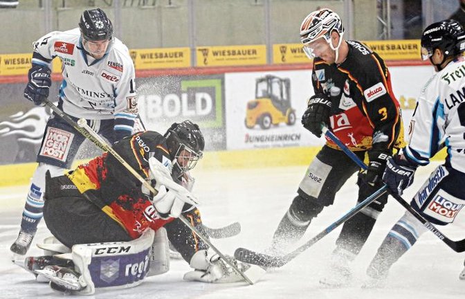Torwart Stephon Williams (links vorne) und Max Prommersberger gewannen in den schwarz-rot-goldenen Trikots das Heimspiel gegen die Dresdner Eislöwen mit 4:1. Foto: Baumann