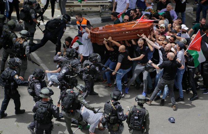 Israelische Polizisten stoßen mit palästinensischen Trauernden zusammen, die den Sarg der getöteten Al-Dschasira-Reporterin Abu Akle tragen. Die Gewalt der Sicherheitskräfte sorgt international für Bestürzung.<span class='image-autor'>Foto: Maya Levin/AP/dpa</span>