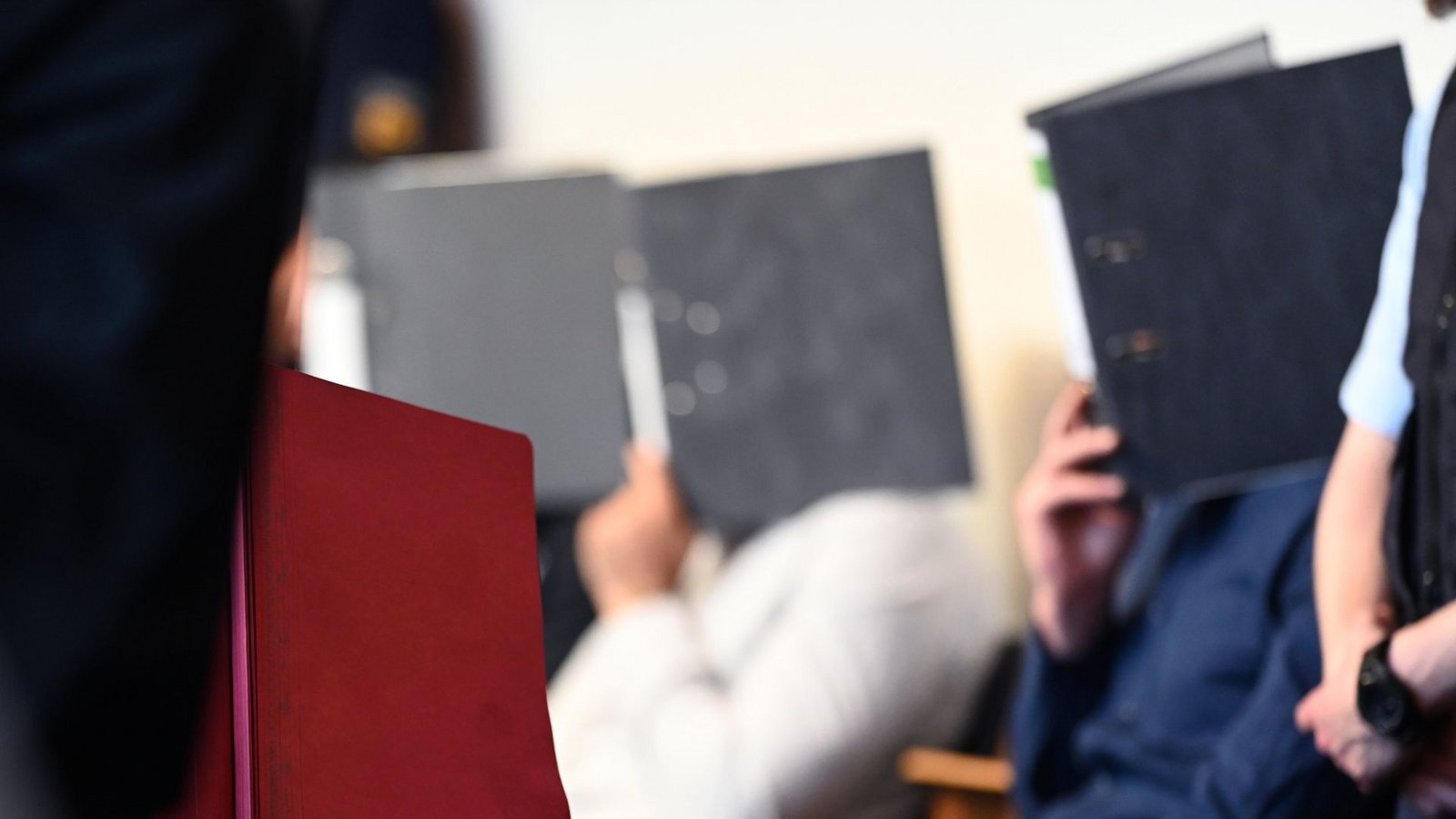 Zum Prozessauftakt im Juli 2019 verstecken sich die Angeklagten hinter Aktenordnern.Foto: dpa/Patrick Seeger