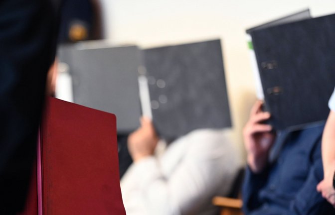 Zum Prozessauftakt im Juli 2019 verstecken sich die Angeklagten hinter Aktenordnern.<span class='image-autor'>Foto: dpa/Patrick Seeger</span>