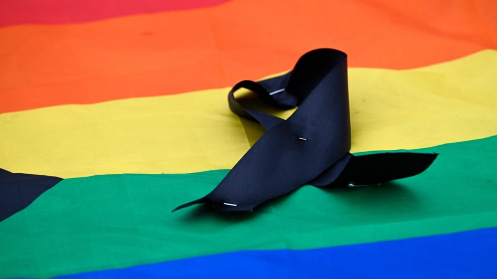 Trauer am Tag, an dem der Berliner Christopher Street eigentlich in seinen zweiten Tag starten sollte: Eine Regenbogenflagge mit einer Trauerschleife am Sonntag vor dem Brandenbueger Tor.RALF HIRSCHBERGER/afp