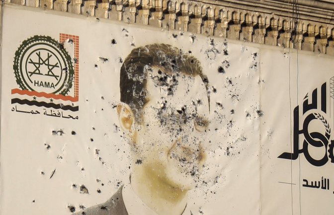 Ein Bild des syrischen Präsidenten Baschar al-Assad in der Stadt Hama, durchlöchert von Kugeln.<span class='image-autor'>Foto: dpa/Omar Albam</span>