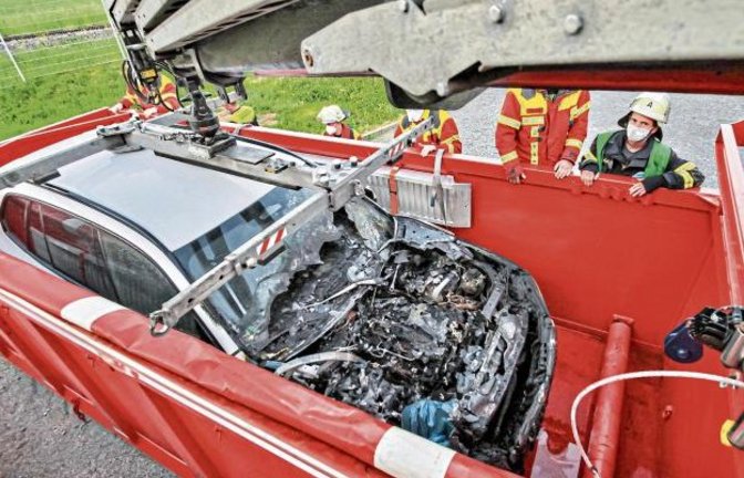 In einer speziellen Mulde musste die Feuerwehr die Lithium-Ionen-Batterie des Hybridfahrzeugs löschen und abkühlen. Foto: KS-Images.de/Andreas Rometsch