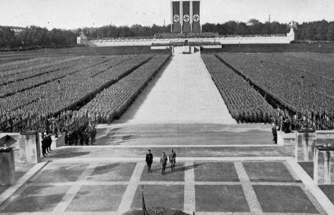 Menschenblöcke als Kulisse: Adolf Hitler, Reichsführer-SS   Himmler  und  SA-Führer  Lutze schreiten beim Reichsparteitag 1934 zur  Totenehrung in der Luitpoldarena.

Foto: imago<span class='image-autor'>Foto: &nbsp;</span>