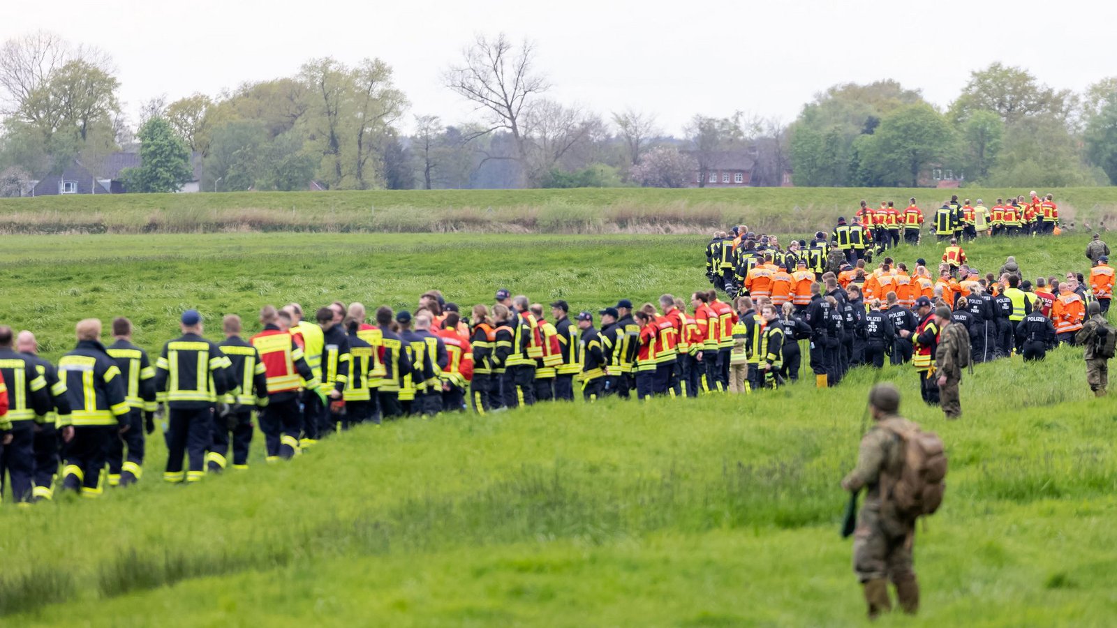 Soldaten der Bundeswehr und Einsatzkräfte von Feuerwehr und Polizei stellen sich auf, um ein Feld abzusuchen.Foto: dpa/Bodo Marks