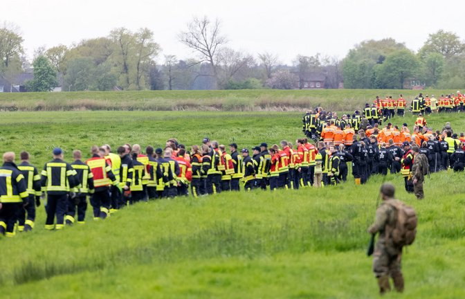 Soldaten der Bundeswehr und Einsatzkräfte von Feuerwehr und Polizei stellen sich auf, um ein Feld abzusuchen.<span class='image-autor'>Foto: dpa/Bodo Marks</span>