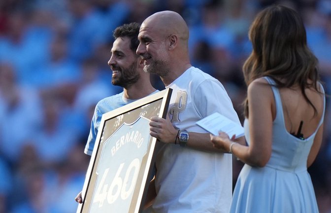 Bernardo Silva (l) und Trainer Pep Guardiola während einer Zeremonie nach ihrem letzten Spiel für Manchester City.<span class='image-autor'>Foto: Alastair Grant/AP/dpa</span>