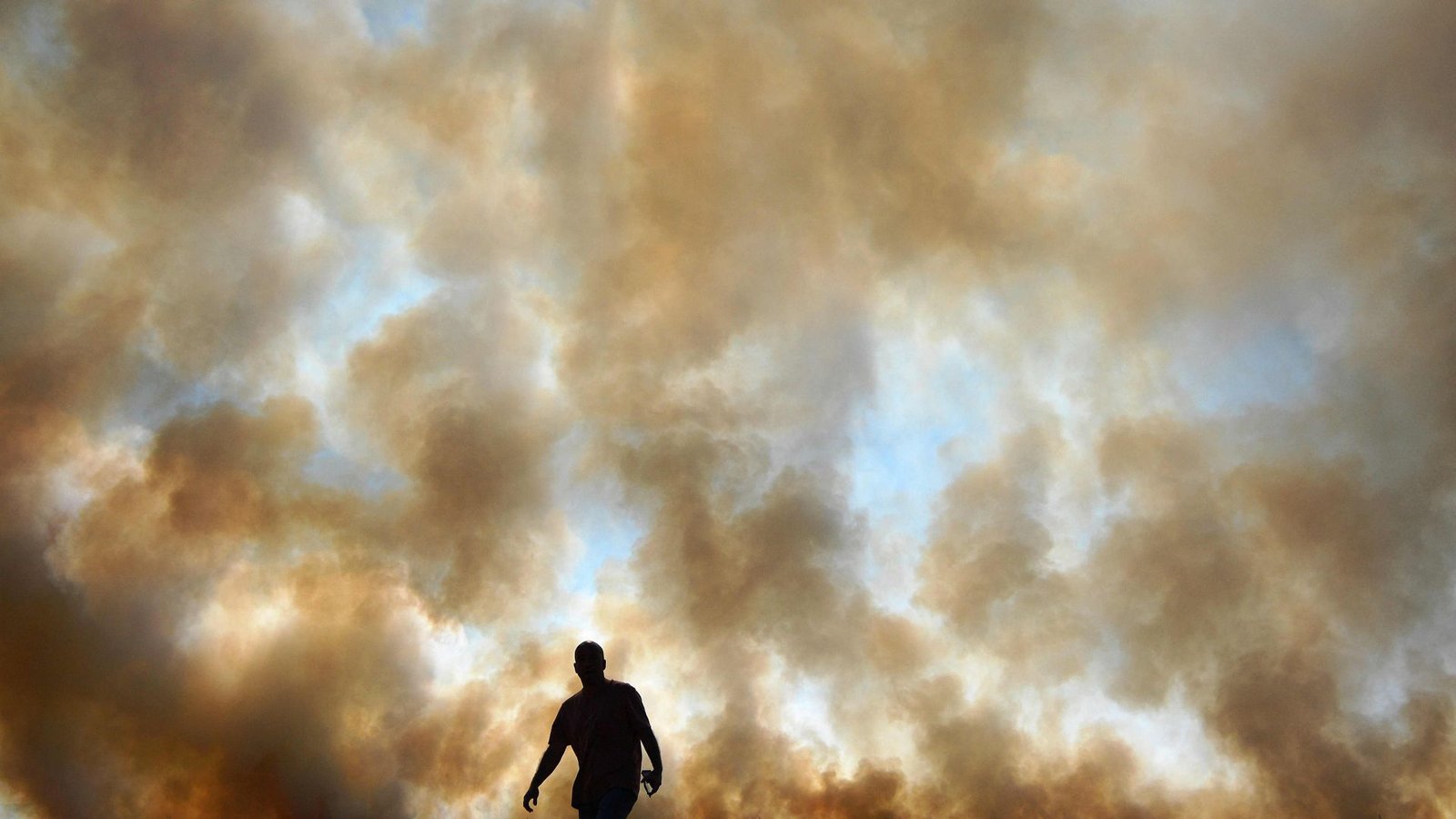 Dieses Foto zeigt einen Mann vor einem Feuer, das illegalerweise auf einem Maisfeld in der Nähe des Regenwalds in Brasilien gelegt wurde.Foto: AFP/CARL DE SOUZA
