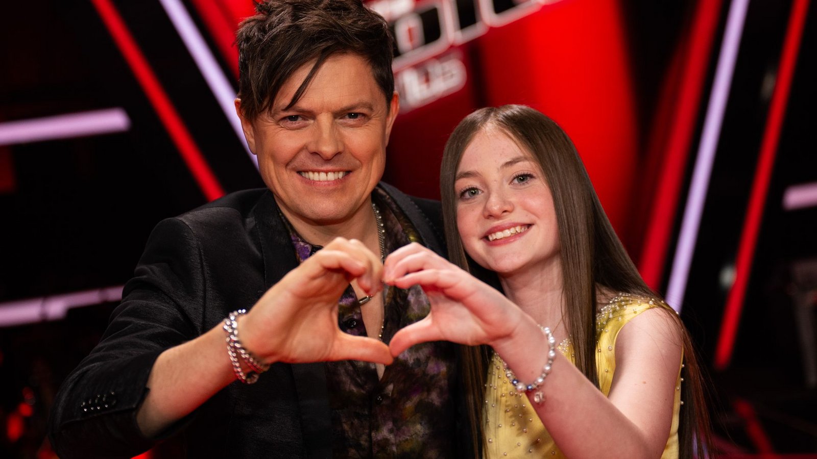 Michael Patrick Kelly steht beim Finale der Musikshow "The Voice Kids" neben Kandidatin Katelyn auf der Bühne.Foto: Christophe Gateau/dpa Michael Patrick Kelly steht beim Finale der Musikshow "The Voice Kids" neben Kandidatin Katelyn auf der Bühne.Foto: Christophe Gateau/dpa