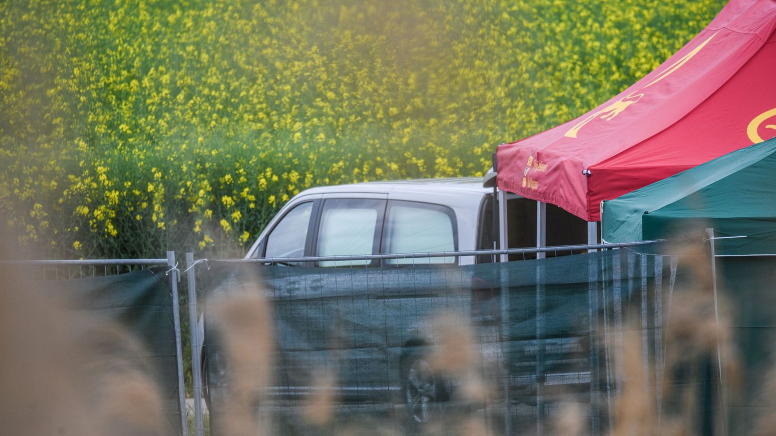 Ein Leichenwagen steht auf einem Feldweg in Baden-Württemberg, wo eine tote Frau in einem Auto entdeckt wurde.Foto: Jason Tschepljakow/dpa/Jason Tschepljakow