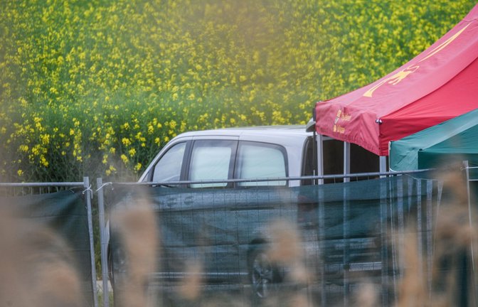 Ein Leichenwagen steht auf einem Feldweg in Baden-Württemberg, wo eine tote Frau in einem Auto entdeckt wurde.<span class='image-autor'>Foto: Jason Tschepljakow/dpa/Jason Tschepljakow</span>