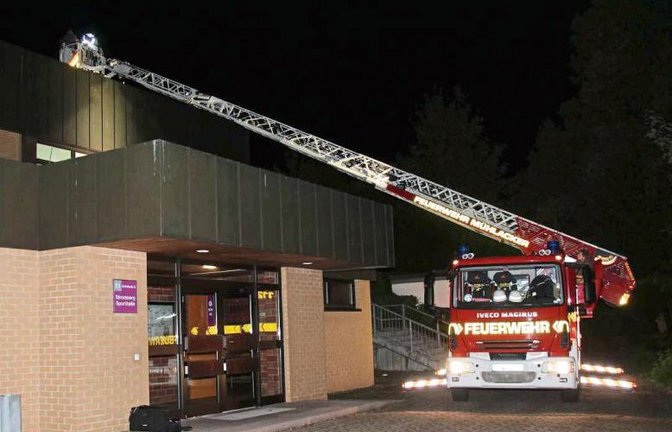 Mit der Drehleiter werden die Kriminalpolizisten aufs Dach der Halle gehievt.