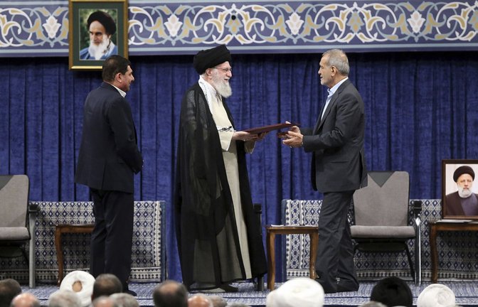 Irans Religionsführer Ajatollah Ali Chamenei (M) gibt dem neu gewählten iranischen Präsidenten Massud Peseschkian sein offizielles Gütesiegel.<span class='image-autor'>Foto: dpa/Uncredited</span>