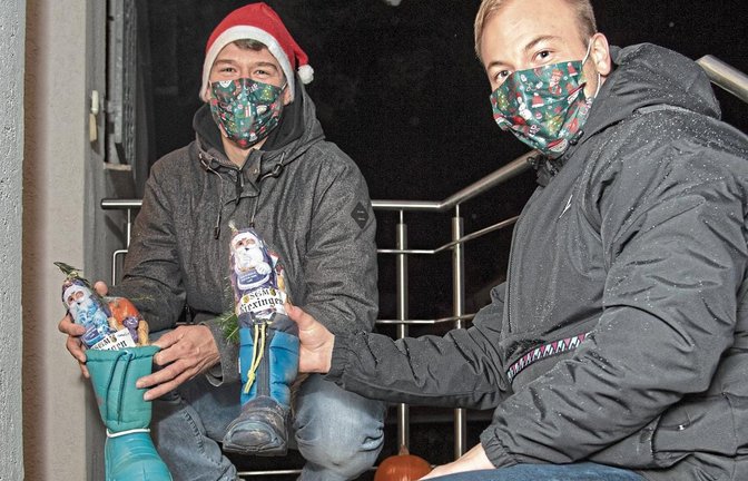 Tobias Mäule (links) und Bastian Schaar verteilen am Sonntagabend bei einer Aktion des Fußball-A-Ligisten SGM Riexingen Nikoläuse. Foto: Leitner