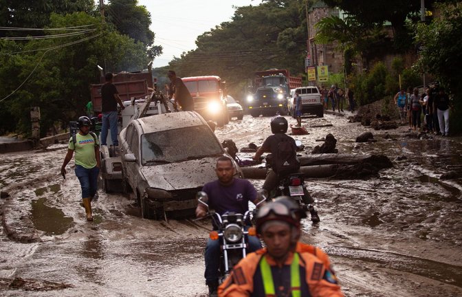 Menschen und Fahrzeuge stecken im Schlamm der durch Überschwemmungen und Erdrutsche auf die Straßen kam. Heftige Regenfälle in Venezuela führten zu Hochwasser in der Stadt Maracay im Bundesstaat Aragua. Es gab mehrere Todesopfer.<span class='image-autor'>Foto: Juan Carlos Hernandez/ZUMA Press Wire/dpa</span>