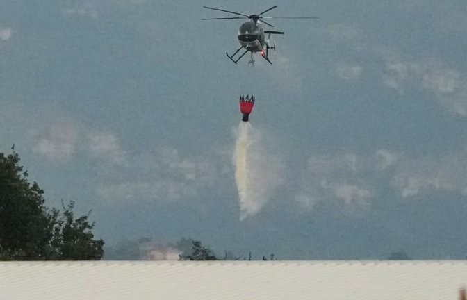 Ein Hubschrauber wirft Wasser über den Ort einer Explosion in einer Munitionsfabrik in Colleferro bei Rom ab. In einer Munitionsfabrik unweit der italienischen Hauptstadt Rom ist es nach einem Brand zu einer Explosion gekommen.<span class='image-autor'>Gregorio Borgia/AP/dpa</span>