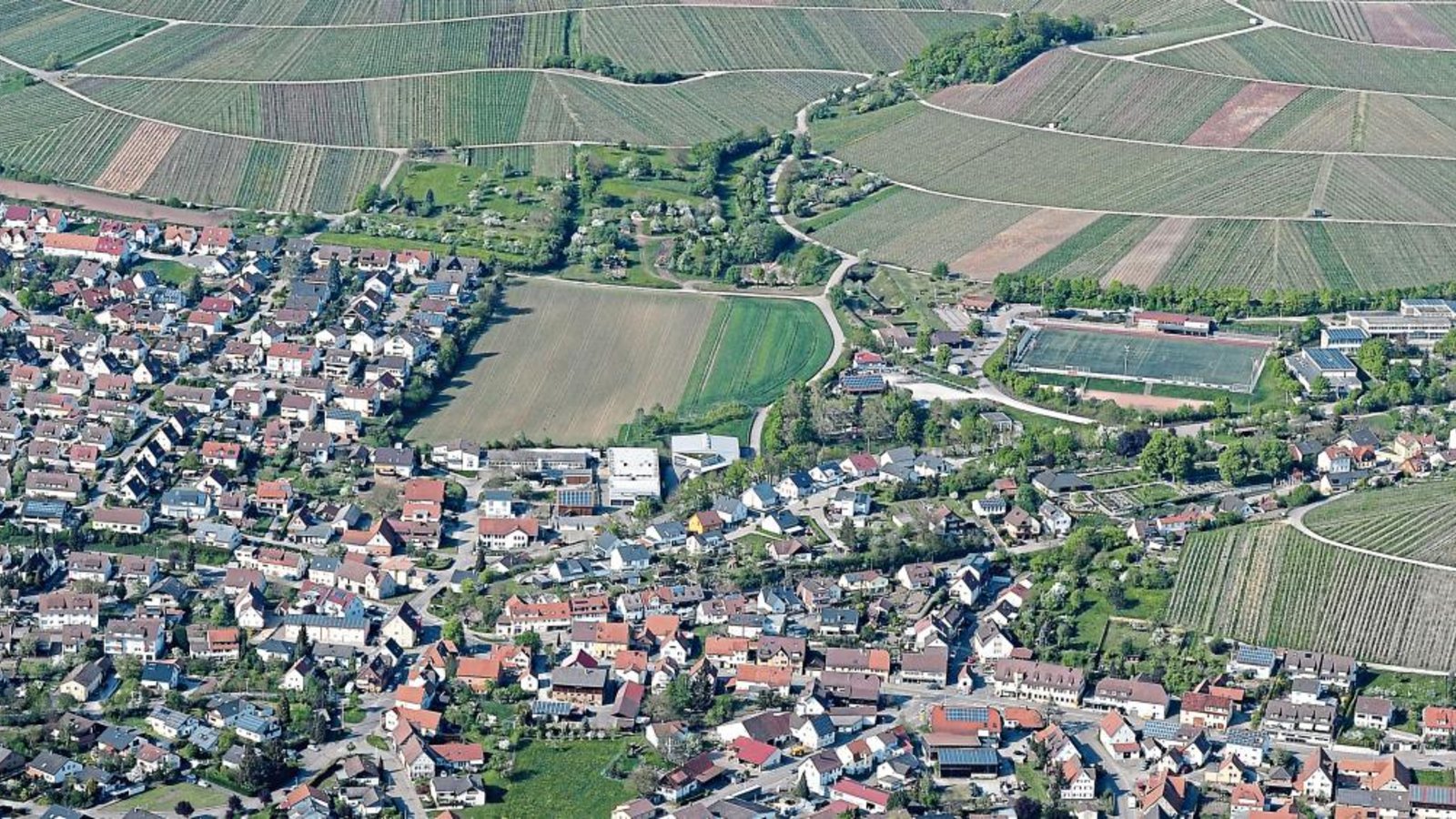 Ein 1,5 Hektar großer Teil der freien Fläche (Bildmitte links vom Sportplatz) in Hohenhaslach könnte zum Gewerbegebiet werden.  Foto: Kuhnle